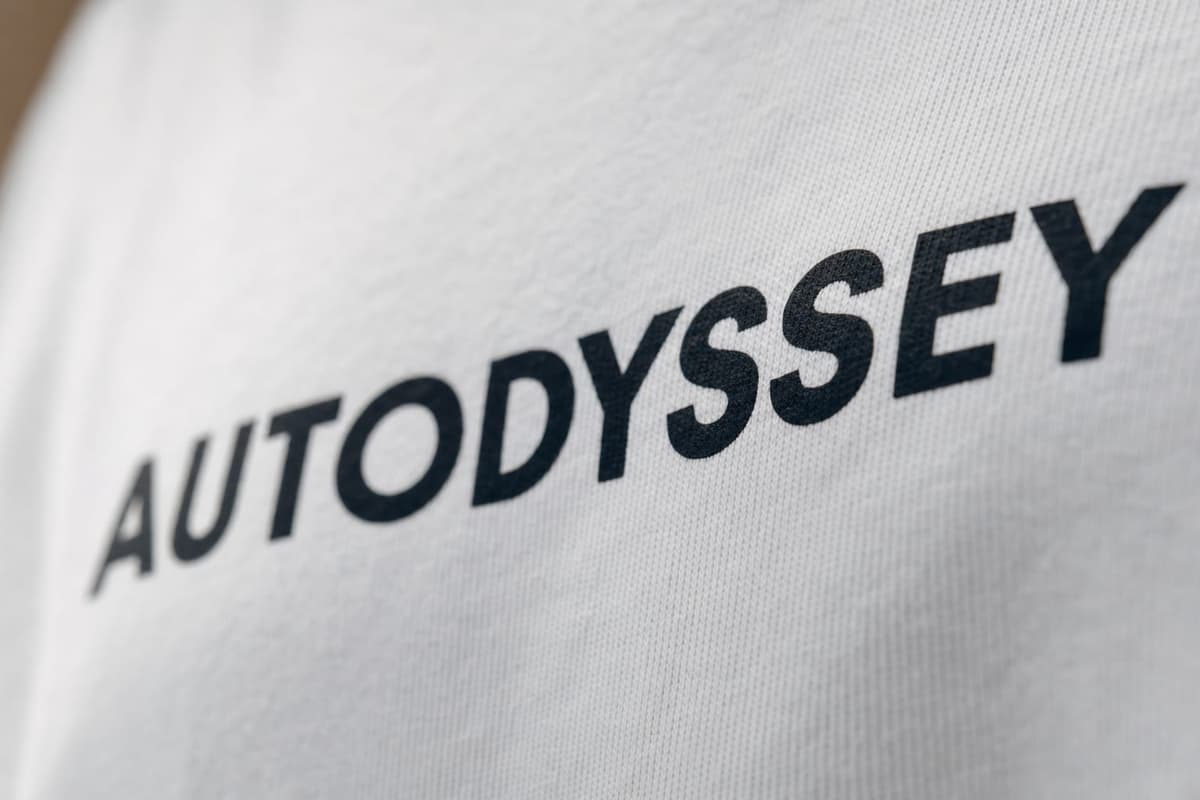A close-up of the black AUTODYSSEY print on white cotton
